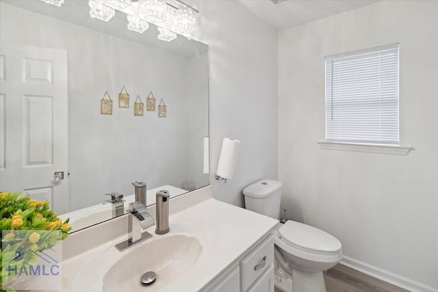 bathroom featuring wood-type flooring, vanity, and toilet