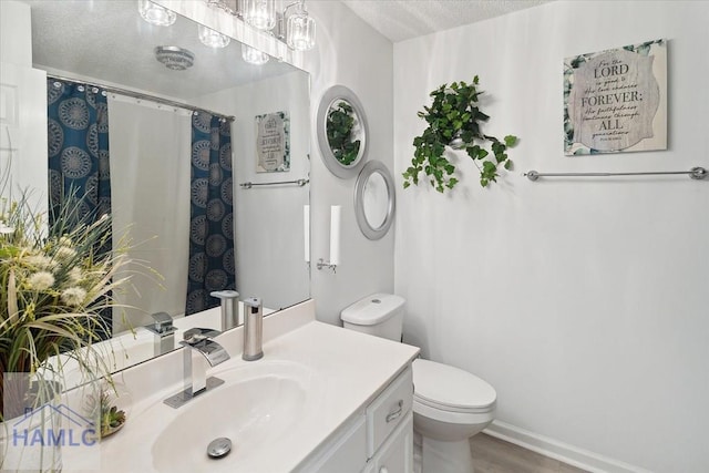 bathroom featuring hardwood / wood-style flooring, vanity, toilet, and a textured ceiling