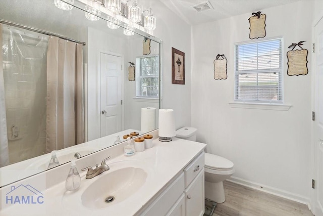 bathroom with a shower with shower curtain, vanity, hardwood / wood-style flooring, and toilet