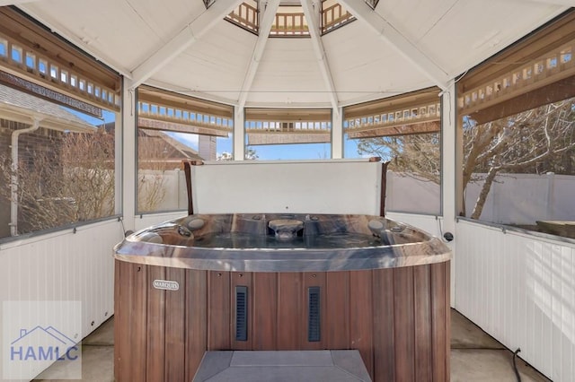 sunroom with a hot tub and vaulted ceiling