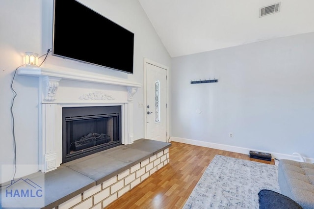 unfurnished living room featuring vaulted ceiling and light wood-type flooring