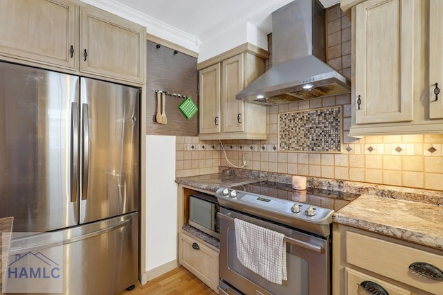 kitchen with appliances with stainless steel finishes, tasteful backsplash, crown molding, light brown cabinets, and wall chimney exhaust hood