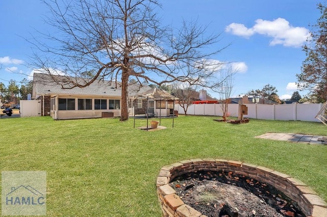 view of yard featuring a gazebo, a sunroom, and a fire pit