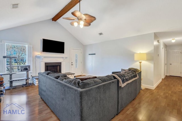 living room featuring vaulted ceiling with beams, hardwood / wood-style floors, and ceiling fan