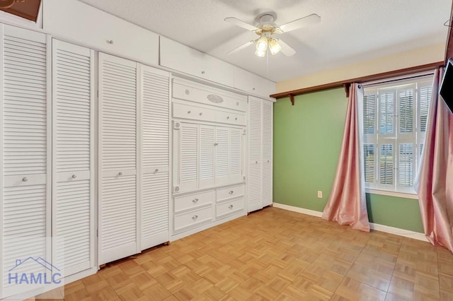 unfurnished bedroom with light parquet floors, a textured ceiling, and ceiling fan