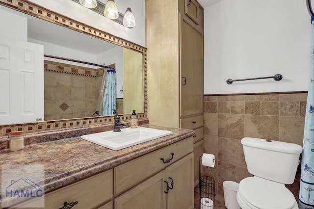 bathroom with tile walls, vanity, curtained shower, and toilet