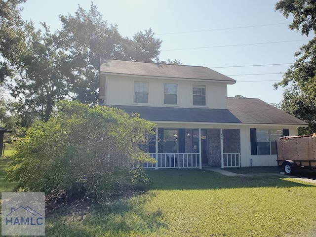 rear view of house featuring a lawn and covered porch