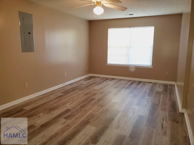 unfurnished room featuring electric panel, ceiling fan, and wood-type flooring