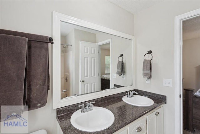 128 W Kenny Dr, Hinesville, GA 31313 - bathroom featuring double vanity, connected bathroom, a textured ceiling, and shower / washtub combination