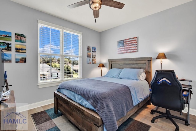 bedroom featuring a ceiling fan, baseboards, and wood finished floors