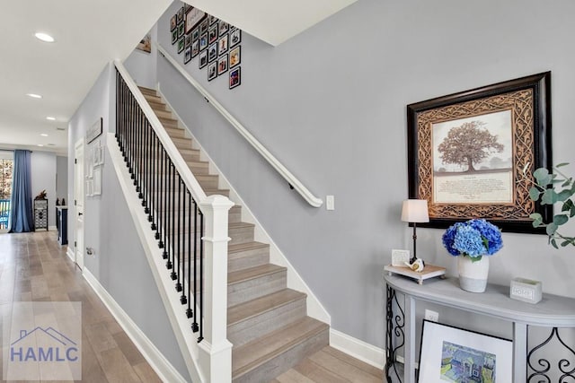 stairs with recessed lighting, wood finished floors, and baseboards