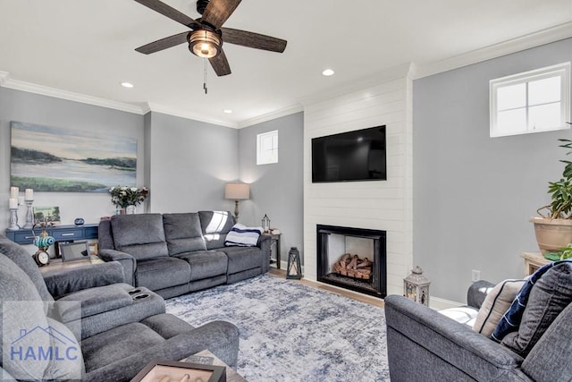 living area featuring crown molding, baseboards, ceiling fan, recessed lighting, and a fireplace