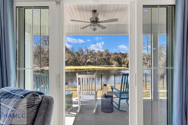 exterior space with a ceiling fan and a water view