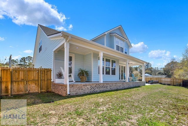 back of house with a lawn and a fenced backyard