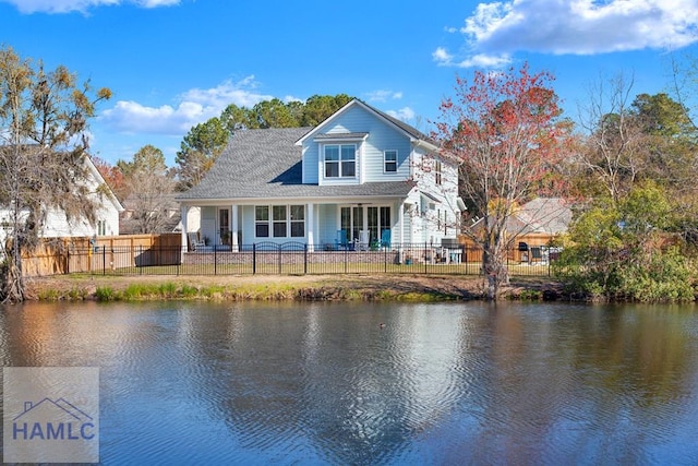 rear view of house featuring a water view and fence private yard