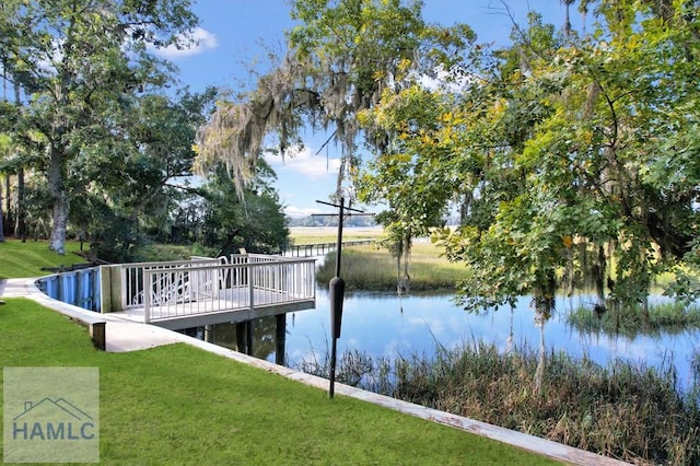 dock area featuring a water view and a lawn