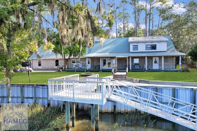 back of house with a yard, french doors, and a deck with water view