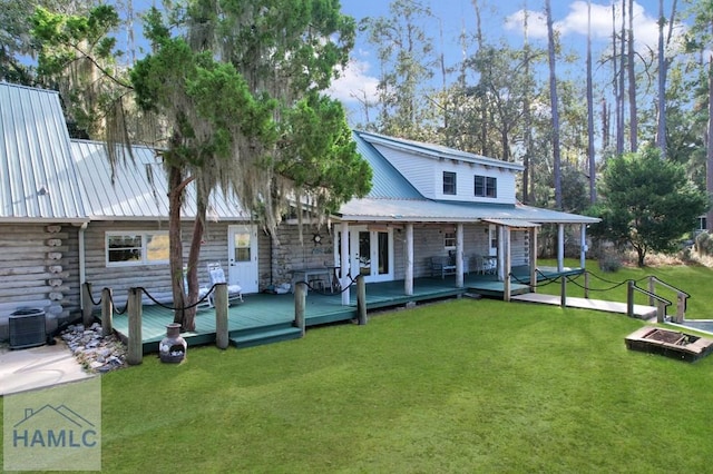 rear view of house with french doors, central air condition unit, a wooden deck, and a lawn