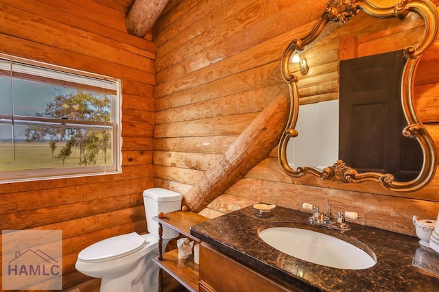 bathroom with vanity, toilet, and rustic walls