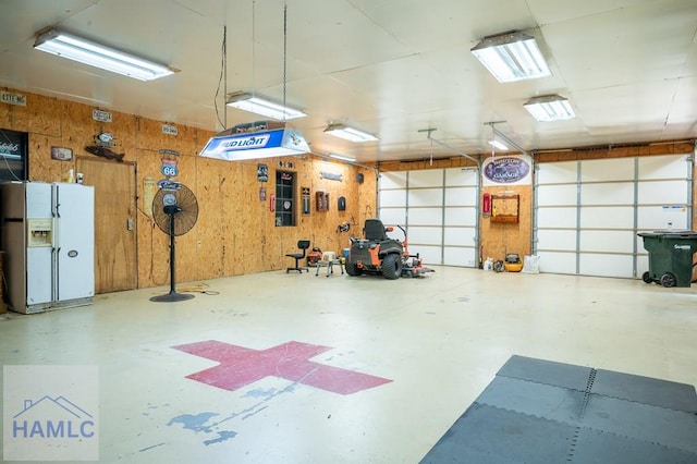 3638 Tibet Rd, Ludowici, GA 31316 - garage featuring white refrigerator with ice dispenser and wood walls