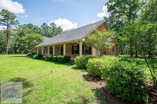3638 Tibet Rd, Ludowici, GA 31316 - view of front of home with a porch, a front lawn, brick siding, and roof with shingles