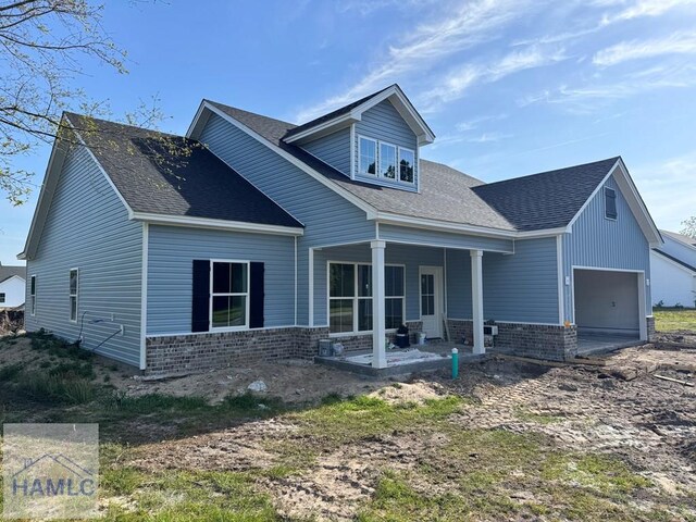 47 Ennis Rd, Pembroke, GA 31321 - rear view of property with brick siding, a garage, and a shingled roof
