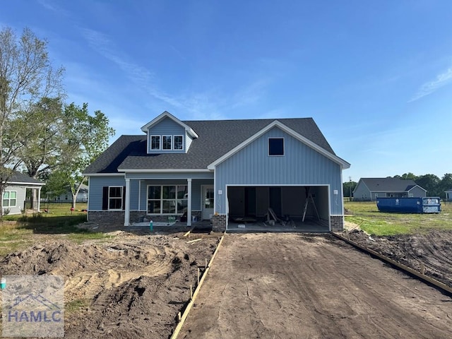 47 Ennis Rd, Pembroke, GA 31321 - view of front of property with dirt driveway, a porch, a garage, board and batten siding, and a shingled roof