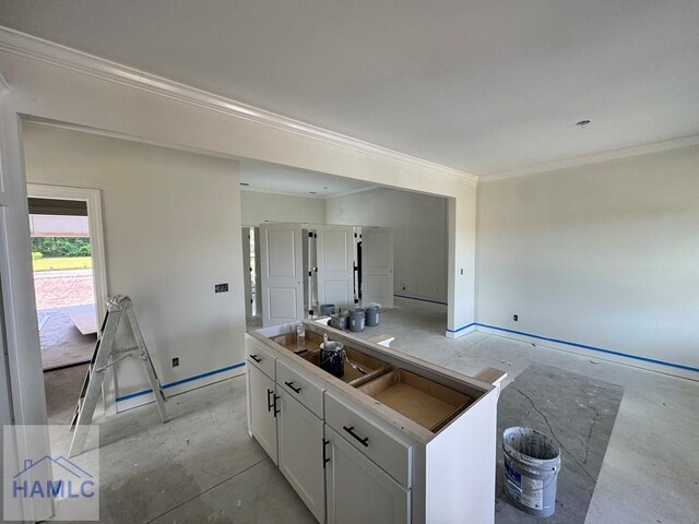 47 Ennis Rd, Pembroke, GA 31321 - kitchen featuring ornamental molding, white cabinetry, concrete floors, and a kitchen island