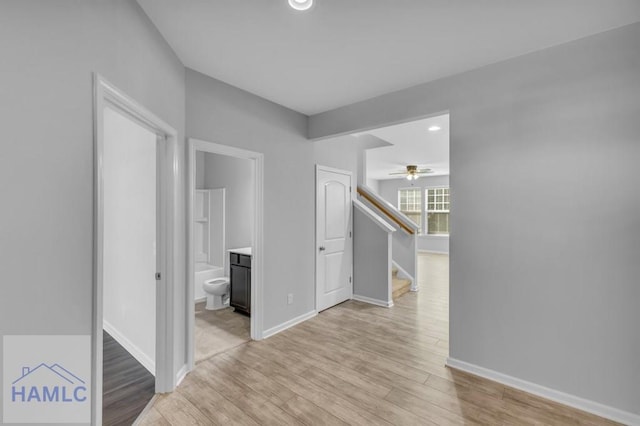 hallway with baseboards, recessed lighting, light wood finished floors, and stairway