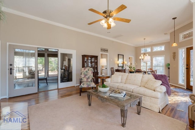 living room featuring ornamental molding, dark hardwood / wood-style floors, and ceiling fan with notable chandelier