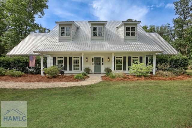 view of front facade with a front yard, a porch, and metal roof