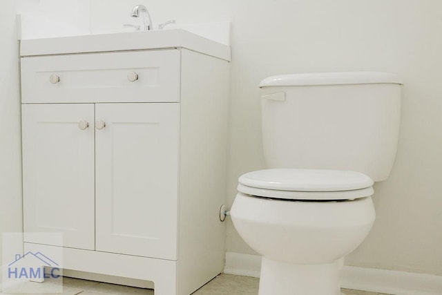 bathroom featuring tile patterned flooring, vanity, and toilet