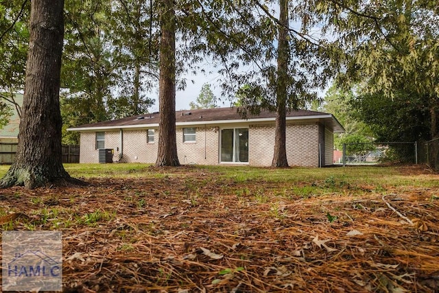 rear view of house featuring a yard and central AC unit