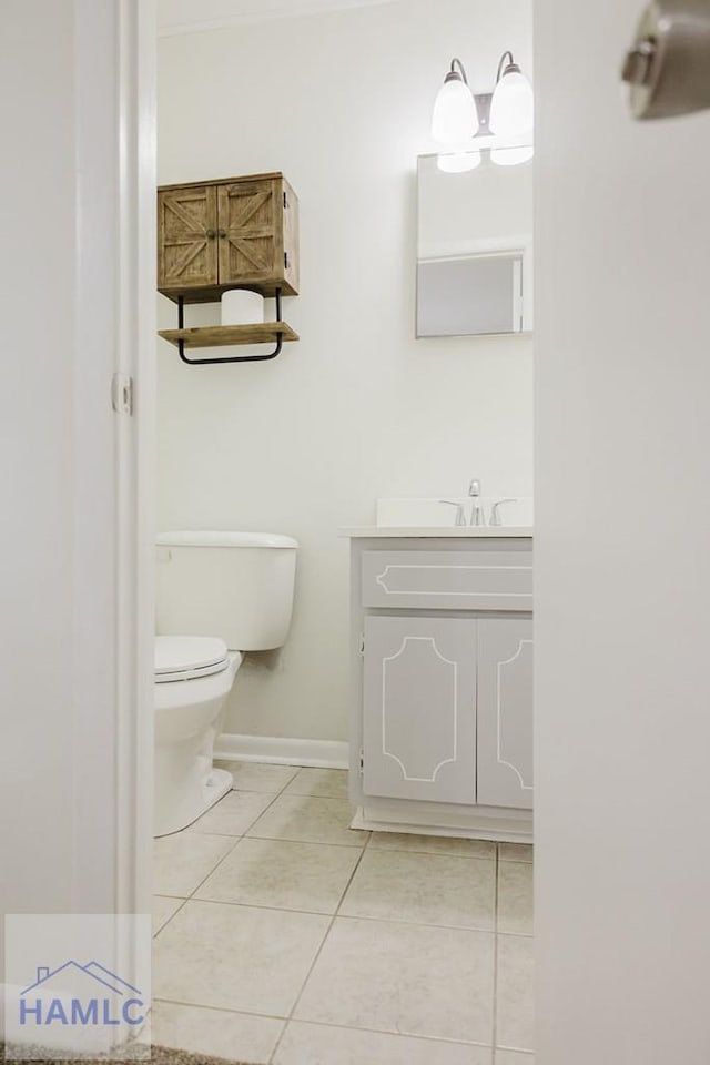 bathroom with tile patterned flooring, vanity, and toilet