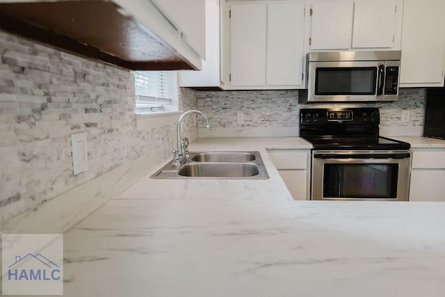 kitchen featuring white cabinetry, sink, appliances with stainless steel finishes, and tasteful backsplash