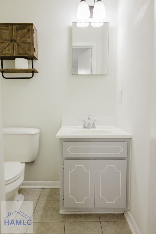 bathroom with tile patterned flooring, vanity, and toilet