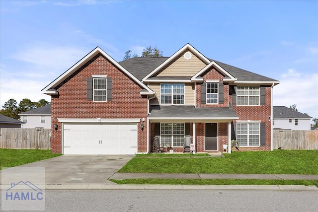 view of front of house featuring a front yard, a garage, and covered porch