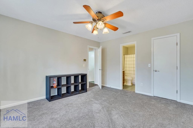 unfurnished bedroom with carpet floors, connected bathroom, and ceiling fan