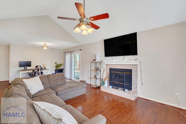 living room featuring hardwood / wood-style flooring, a fireplace, ceiling fan, and vaulted ceiling