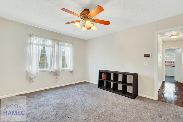 empty room with ceiling fan and dark carpet