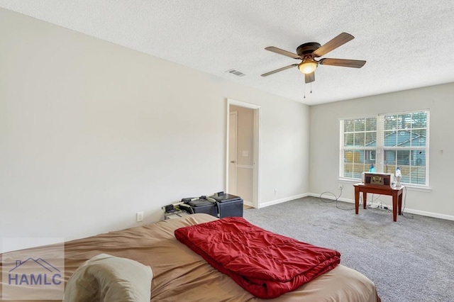 bedroom with ceiling fan, carpet, and a textured ceiling