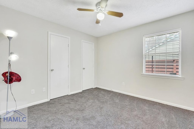 unfurnished bedroom with ceiling fan, carpet floors, and a textured ceiling