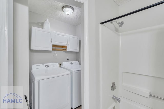 clothes washing area featuring independent washer and dryer and a textured ceiling