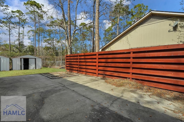 view of side of home featuring a storage shed and a patio area