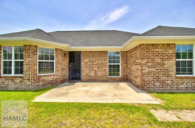 doorway to property featuring a lawn and a patio area