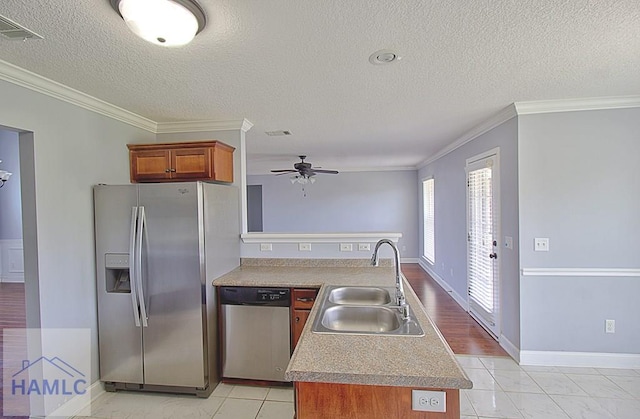 kitchen with plenty of natural light, stainless steel appliances, a textured ceiling, and sink