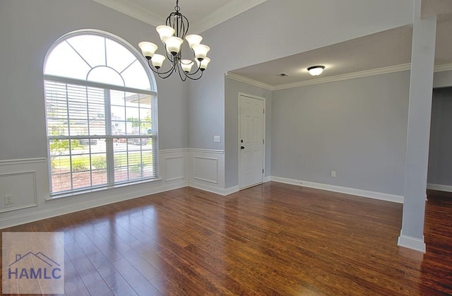 spare room with ornamental molding, dark wood-type flooring, and an inviting chandelier