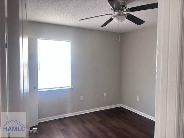 spare room with ceiling fan, a textured ceiling, and dark hardwood / wood-style floors