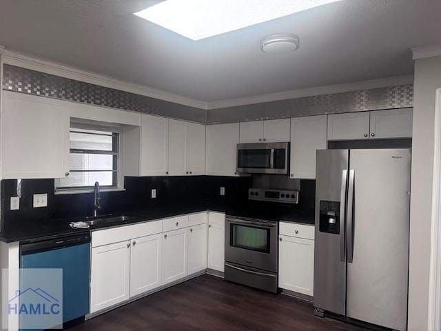 kitchen with stainless steel appliances, white cabinetry, sink, and ornamental molding