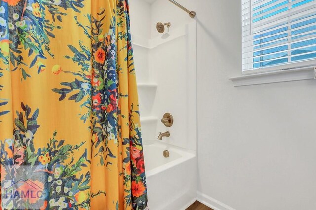 bathroom with a healthy amount of sunlight, wood finished floors, and a sink